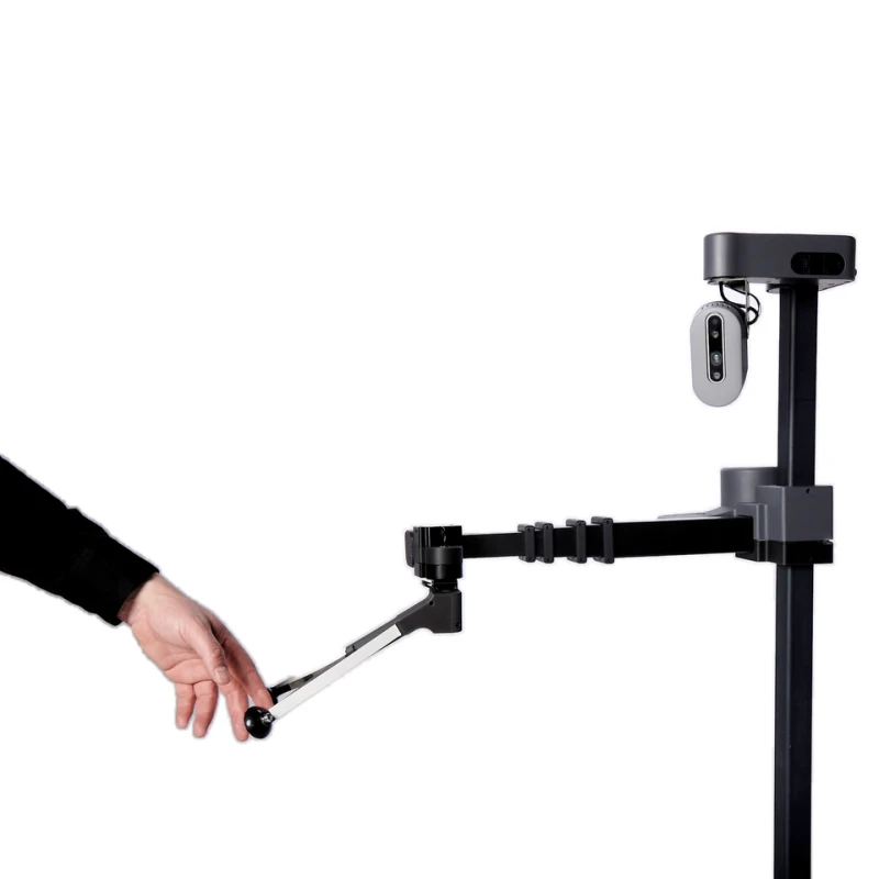 Hello Robot Stretch 3 close-up: dark vertical mast with a pan-tilt camera head at the top and a telescoping arm whose gripper is being held by a person's hand — Humanoid & General Purpose